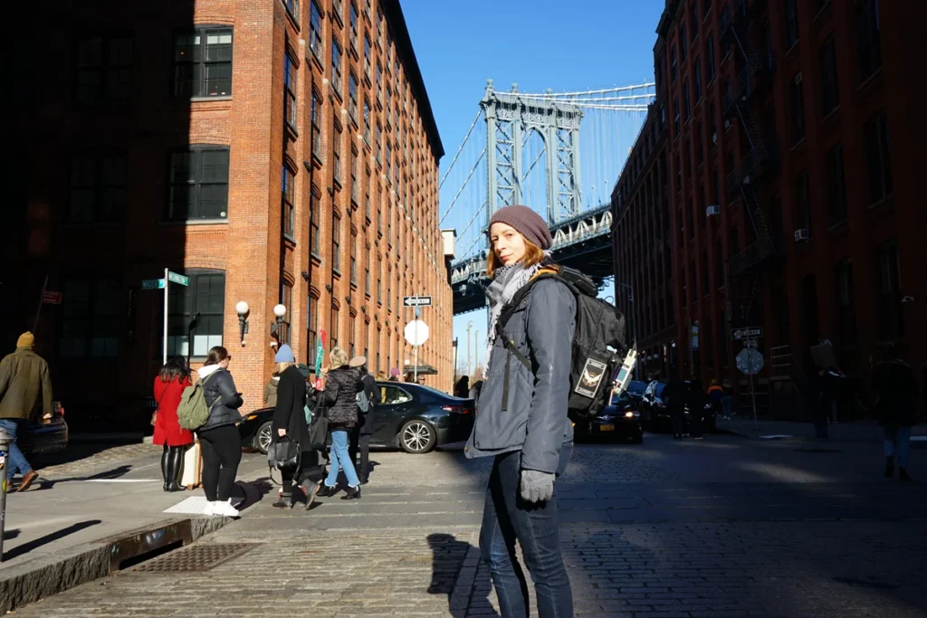 La réalité du terrain : une photo de la célèbre rue de Brooklyn d'où l'on voit le pont de Manhattan, où je pose au milieu de nombreux touristes