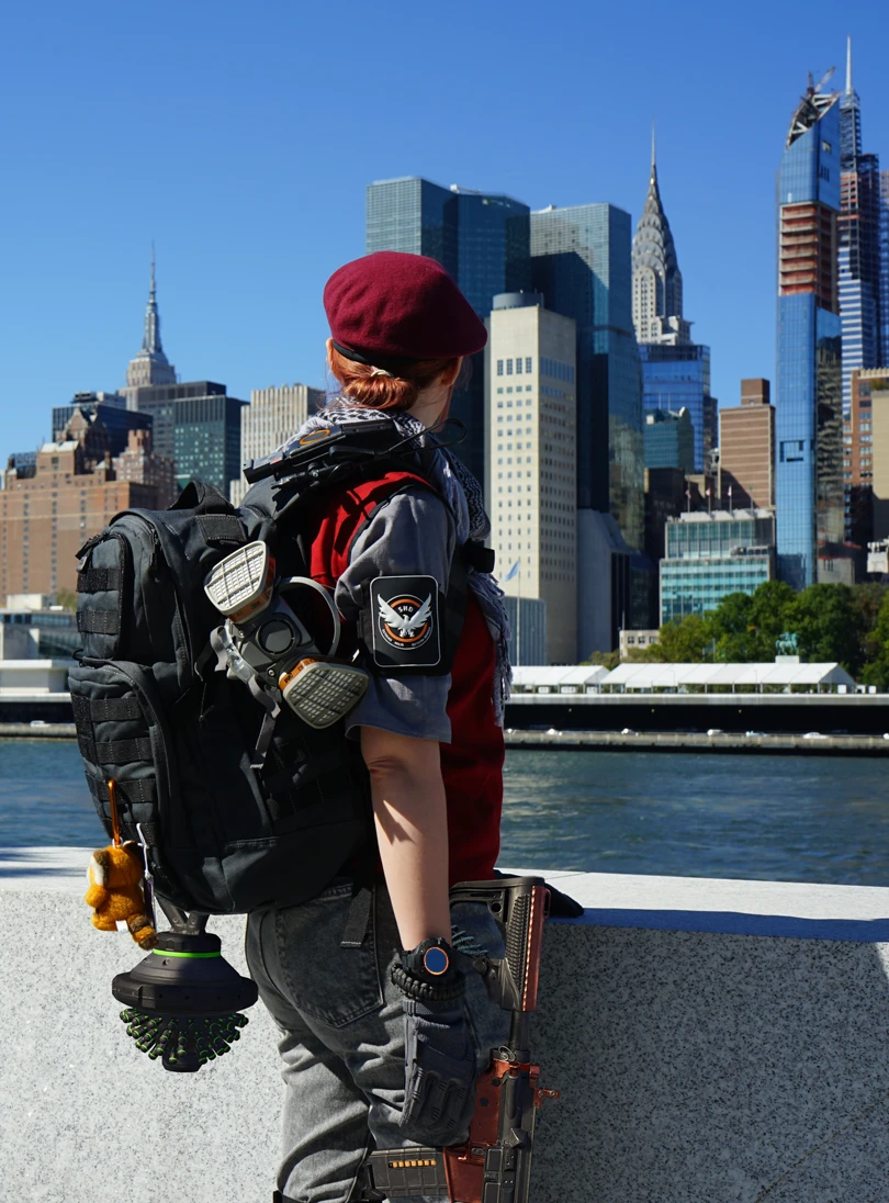 Au bord de la Hudson sur Roosevelt Island, je regarde Manhattan en cosplay de The Division ; divers éléments que je ne pouvais pas porter en public ont été ajoutés via Photoshop : la ruche de soin et le fusil Eagle Bearer