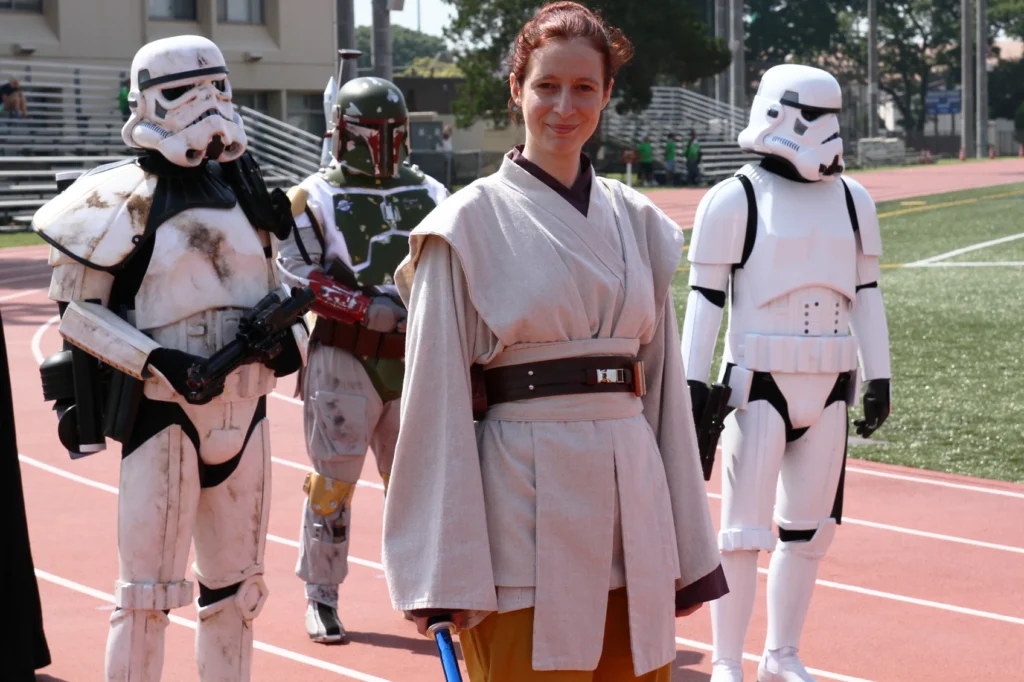 Je pose en costume de Jedi avec des membres de la 501st en tenue de Stormtroopers et de Boba Fett, sur le terrain d'athlétisme d'une base américaine au Japon